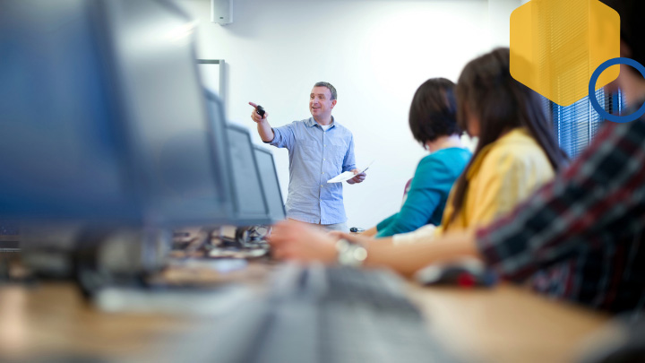 Man teaching group using computers